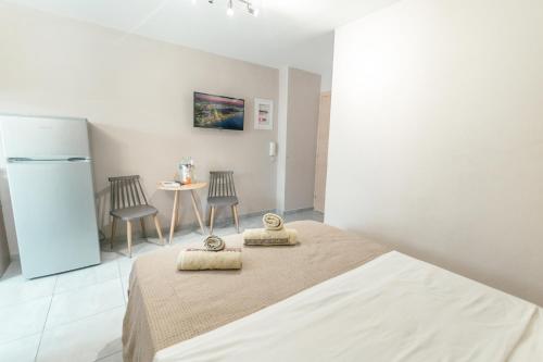 a white room with a bed and a refrigerator at Old Town Elpis Suite in Kos Town