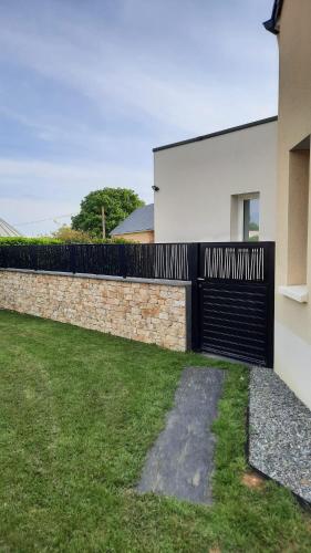 une maison avec un portail noir et un mur dans l'établissement Chambre avec accès privé, à Saint-Saturnin