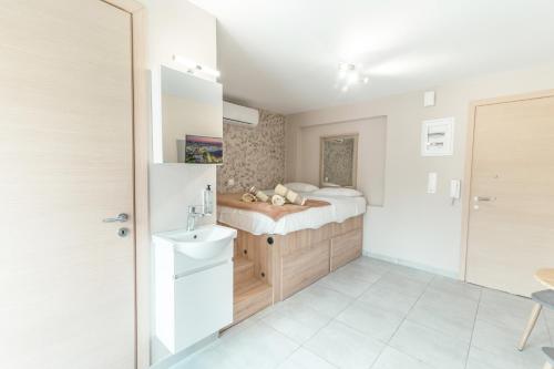 a small bathroom with a bed and a sink at Old Town Euphoria Suite in Kos Town