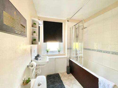 ein Bad mit einem Waschbecken, einem WC und einem Fenster in der Unterkunft Relax and enjoy a unique home near Canterbury City Centre sleeps up to 5 in Canterbury