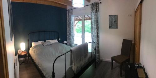 um quarto com uma cama, uma janela e uma cadeira em Chambre d’hôtes calme - Canal Nantes à Brest em Plessé