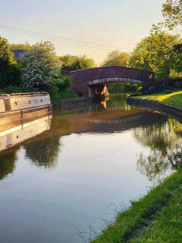 a river with a bridge in the middle of it at Canalside B and B in Yelvertoft