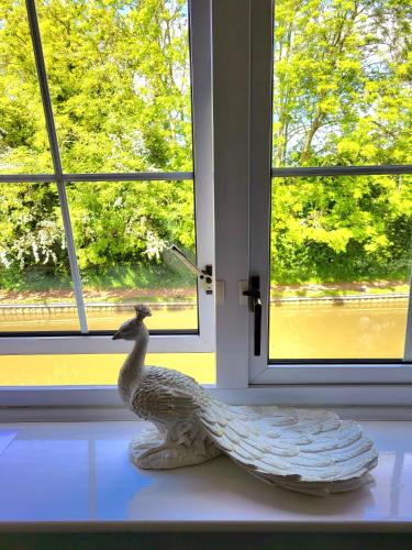 a statue of a duck sitting on a window sill at Canalside B and B in Yelvertoft