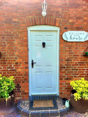 a blue door on the side of a brick building at Canalside B and B in Yelvertoft
