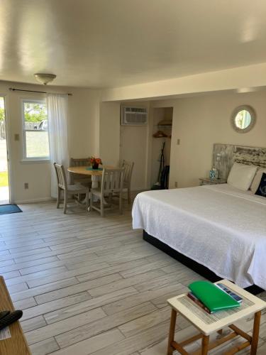 1 dormitorio con 1 cama, mesa y sillas en The Buckingham Motel, en Cape May