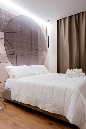 a bedroom with a large white bed with a wooden floor at CALVANI23 LUXURY HOUSE in Bari