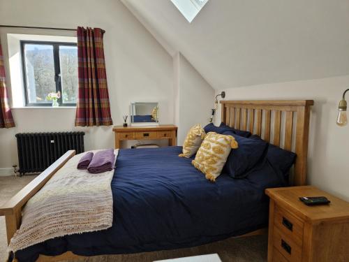a bedroom with a bed with a blue comforter at The Old Pig Sty in Llanellen