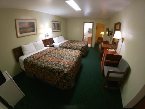 a hotel room with two beds and a chair at Budget Inn Clearfield PA in Clearfield