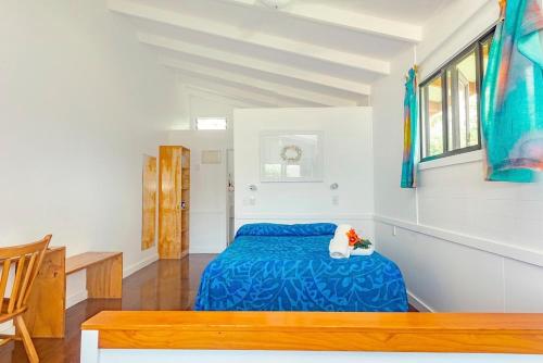 a bedroom with a blue bed in a room at Aroa Beachside Resort in Rarotonga