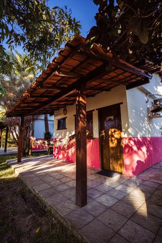 a building with a wooden pergola on top of it at Pousada Estalagem Vila Tania in Itaúnas