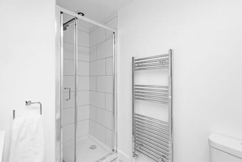 a shower with a glass door in a bathroom at Vine Cottage by Bloom Stays in Canterbury