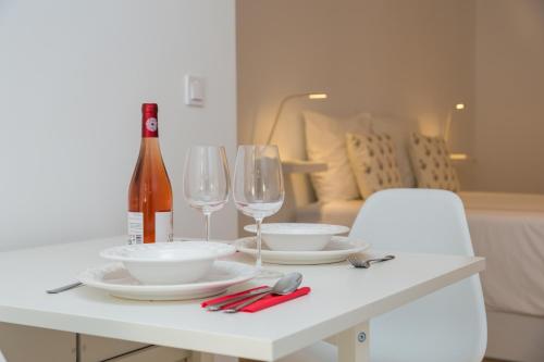 uma mesa branca com dois copos e uma garrafa de vinho em Sado House em Setúbal