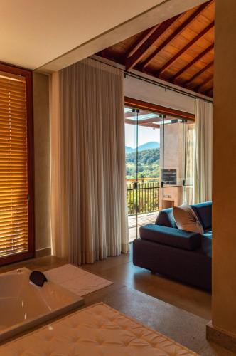 a living room with a bath tub and a couch at Lofts Villa Gratiam in Tiradentes