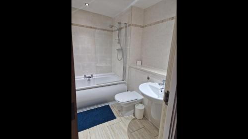 a bathroom with a tub and a toilet and a sink at Remarkable 2-Bed Apartment in Central Liverpool in Liverpool