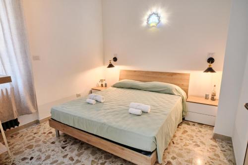 een slaapkamer met een bed met twee handdoeken erop bij Conchiglia & Medusa Home Otranto in Otranto