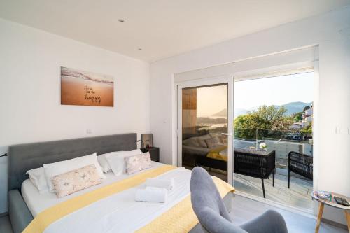 a white bedroom with a bed and a balcony at Dubrovnik Icy Guest House in Dubrovnik