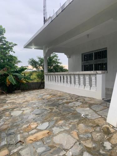 a stone patio in front of a white house at Hermosa casa en Cabarete, Villa Esperanza in Cabarete