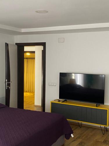 a bedroom with a flat screen tv on a dresser at Zani Boutique Hotel in Prizren