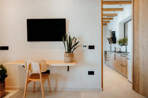 a dining room with a table and a tv on a wall at Villa Mirabilis in Ios Chora