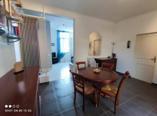 eine Küche und ein Esszimmer mit einem Tisch und Stühlen in der Unterkunft Maison Mathilde et Simone in Andernos-les-Bains