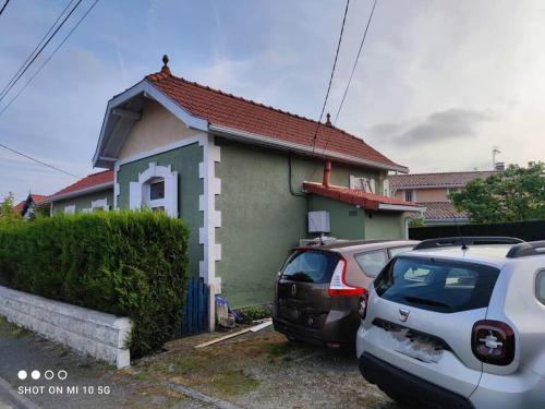 ein Haus mit zwei Autos, die davor geparkt sind in der Unterkunft Maison Mathilde et Simone in Andernos-les-Bains