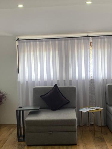 a couch sitting in a living room with a curtain at Zani Boutique Hotel in Prizren