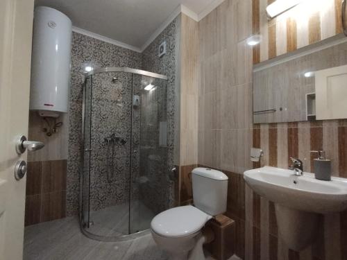 uma casa de banho com um chuveiro, um WC e um lavatório. em Apartament Messambria Resort - Bastet BS em Sunny Beach