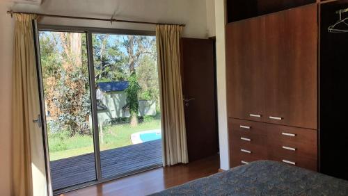1 dormitorio con puerta corredera de cristal que da a un patio en Sierra Natural SDP en Sierra de los Padres