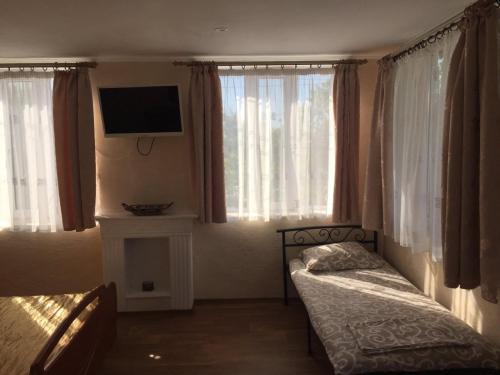 a bedroom with two beds and a tv and windows at MarBlau in Zatoka