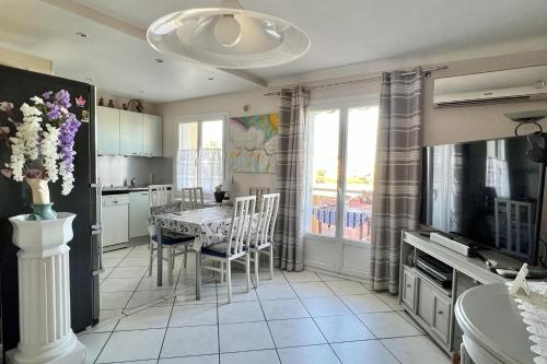 une cuisine avec une table et des chaises et une télévision dans l'établissement 2 room apartment with sea view, à Cannes