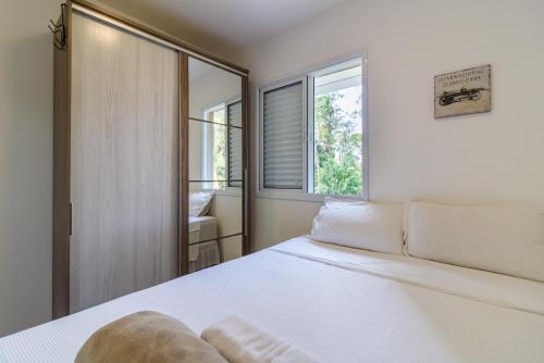 ein Schlafzimmer mit einem weißen Bett und einem Fenster in der Unterkunft Apto próximo ao Estádio Morumbi in São Paulo