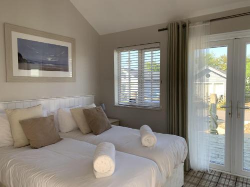 a bedroom with two beds with white pillows at Blue Bay at The Bay Filey, sleeps 4-6, 2 dogs welcome for free too in Filey