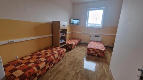 an empty room with two beds and a window at Privat Prešov in Prešov