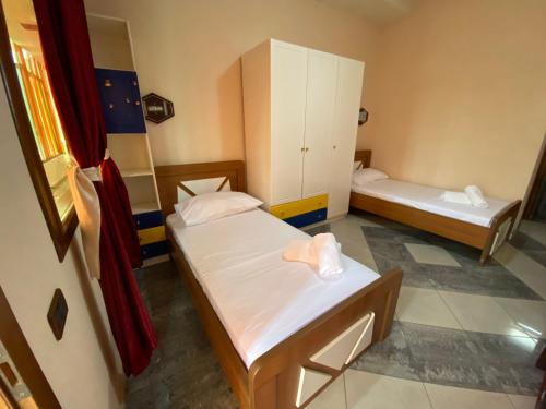 a small room with two beds and a tub at Hotel W Bush Square in Fushë-Krujë