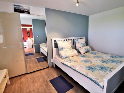 - une petite chambre avec un lit et un miroir dans l'établissement Snug Bungalow in Insel Poel Germany near Beach, à Fährdorf
