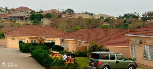 a green suv parked in front of some houses at Stream Box Lodge in Lilongwe