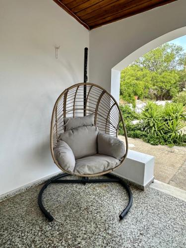 a rattan chair sitting in a room with a window at Aegean Endless Summer Villa Pefkos in Pefki Rhodes