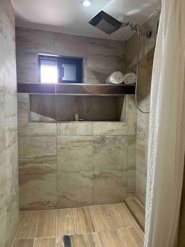 a bathroom with a shower with a glass door at Suite Mirador Deluxe in Chihuahua