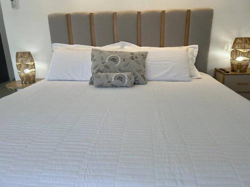 a large white bed with two pillows on it at Suite Mirador Deluxe in Chihuahua