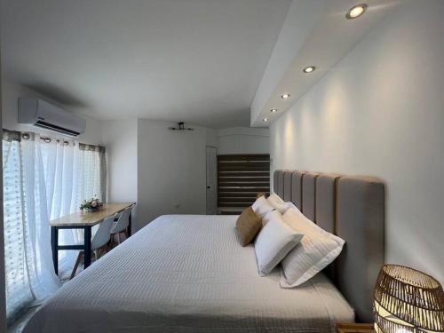 a bedroom with a large bed with a desk and a window at Suite Mirador Deluxe in Chihuahua