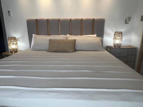 a large white bed with two lamps on two tables at Suite Mirador Deluxe in Chihuahua