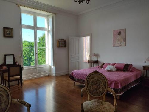 Saint-EstèpheにあるChambres d'hôtes au château de Puycharnaudのベッドルーム(紫の毛布付きのベッド1台付)