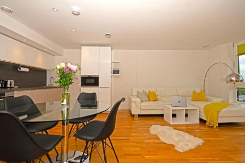 a living room with a glass table and a couch at Kew Bridge Penthouse in London