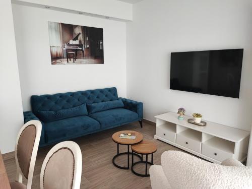 un salon avec un canapé bleu et une télévision dans l'établissement SPLIT VIEW 2 Bedrooms LUXURY APARTMAN 90 m2, à Klis