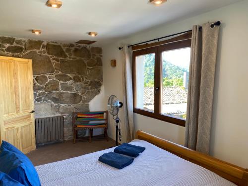 a bedroom with a bed and a large window at Farm house in Ribeira Sacra in O Carballo