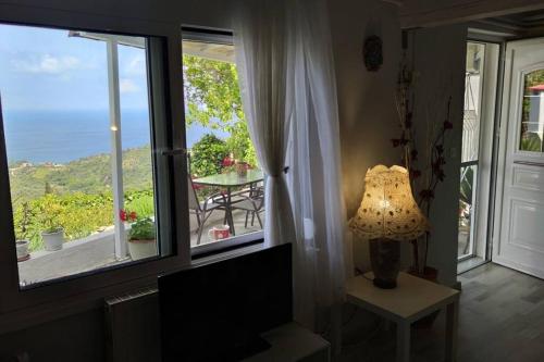 a room with a window with a table and a lamp at Sunrise house in Kymi