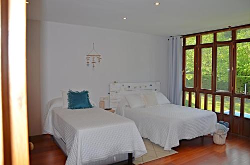 two beds in a room with a window at Villa La Atalaya in Llanes