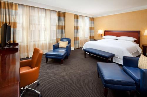 une chambre d'hôtel avec un lit et des chaises dans l'établissement The Gunter Hotel San Antonio Riverwalk, à San Antonio