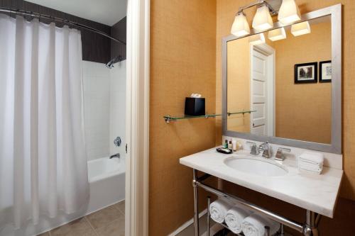 a bathroom with a sink and a tub and a mirror at The Gunter Hotel San Antonio Riverwalk in San Antonio