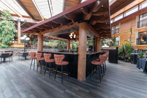 a bar in a restaurant with stools at Prestige Vernon Lodge in Vernon